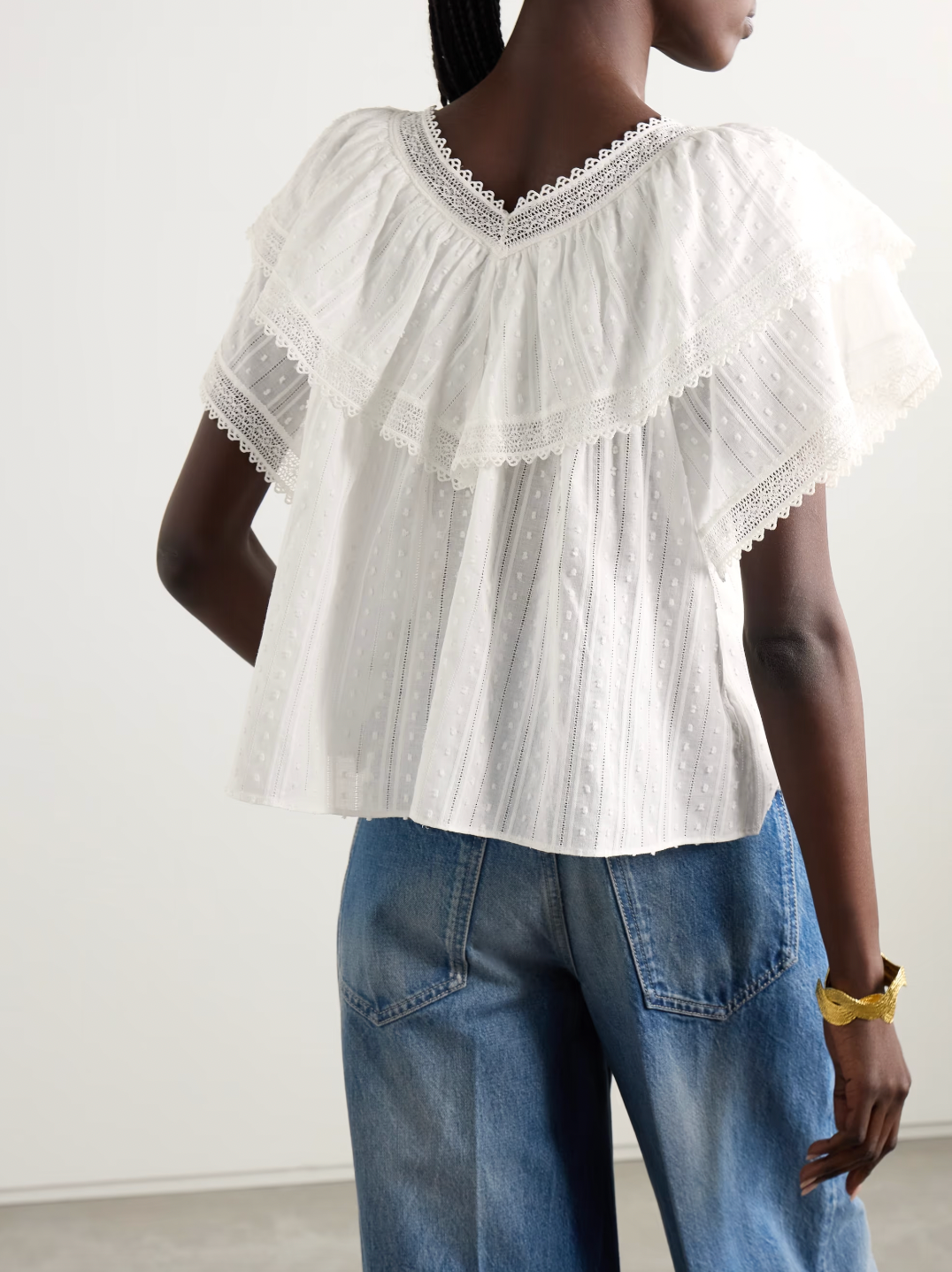 The Cosenza blouse from DÔEN features a delicate fluttery ruffled panel that elegantly highlights the V-neckline and shoulders. Crafted from lightweight fil coupé cotton-voile and accented with airy crochet trims, it offers both comfort and charm. Perfectly versatile, this blouse pairs effortlessly with jeans or flowy skirts, making it a stylish choice for any occasion.