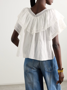 The Cosenza blouse from DÔEN features a delicate fluttery ruffled panel that elegantly highlights the V-neckline and shoulders. Crafted from lightweight fil coupé cotton-voile and accented with airy crochet trims, it offers both comfort and charm. Perfectly versatile, this blouse pairs effortlessly with jeans or flowy skirts, making it a stylish choice for any occasion.