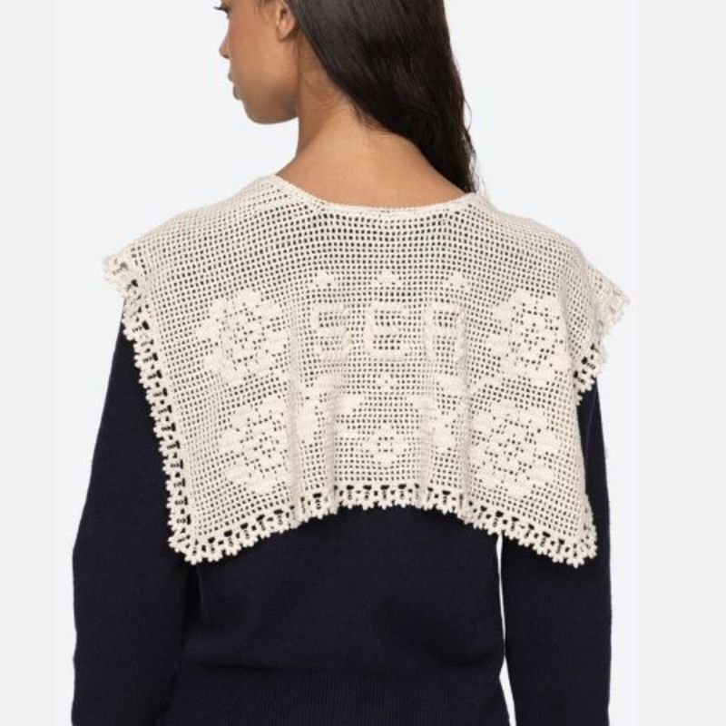 The Marie Cardigan by SEA combines effortless elegance with luxurious comfort. This sophisticated knit features a flattering v-neckline, intricate crochet capelet detail, and an embroidered 'Sea' logo on the cuff. Crafted from premium extra fine merino wool with cotton combo accents, it delivers a soft, breathable wear that moves with you. The relaxed button-front silhouette strikes the perfect balance between polished and comfortable, making it an essential layering piece for any wardrobe. 