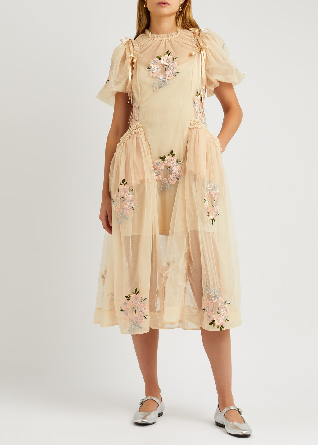 This floral-embroidered tulle midi dress by Simone Rocha embodies romance and elegance with its delicate sheer fabric and calf-length silhouette. Satin bows at the shoulders add a touch of refinement, while intricate floral embroidery, ruffled trims, and ruched details create a captivating, feminine look. Its flowing, loose skirt offers graceful movement, making it perfect for any special occasion where you want to stand out with timeless charm.