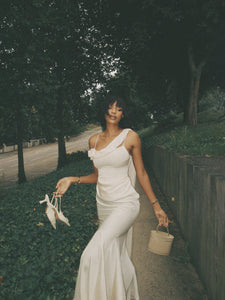 Elevate your elegance with the Celine Corset Gown, a luxurious satin masterpiece designed to flatter every figure. Featuring a corset waist that sculpts your silhouette and graceful draping at the hips, this gown enhances your natural curves. The asymmetric design highlights a delicate rosette on one shoulder and a flowing scarf on the other, adding a unique touch of sophistication. The slightly flared hemline completes this stunning look, perfect for making a memorable entrance at any special occasion.