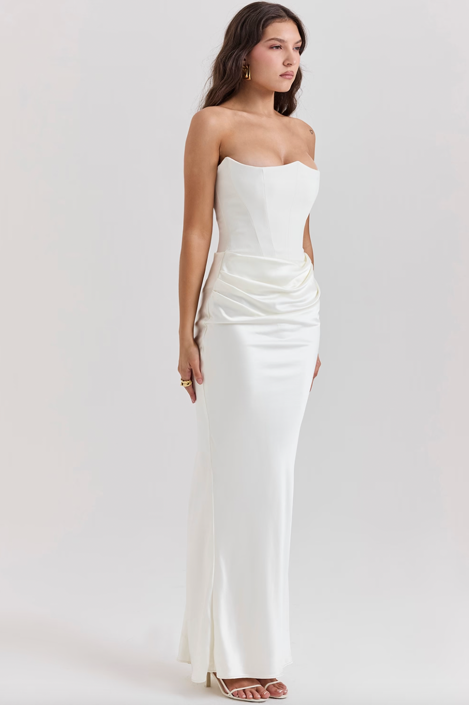 Indulge in luxury with the Ivory Strapless Corset Dress. Perfect for any high-octane occasion, this dress is crafted from stretch crepe and ultra luxe satin. The strapless neckline and boned bodice cinch the waist, while the beautifully draped skirt creates a striking silhouette. Make a statement with its flattering dress.