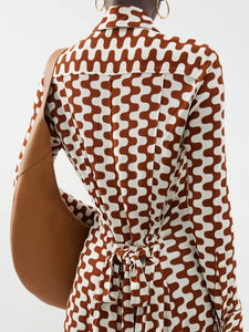 Embrace retro chic with Proenza Schouler's Printed-Jersey Maxi Shirt Dress. The brown and cream zigzag motif adds a playful touch to this sophisticated dress, made from comfortable jersey with a flattering tie-back waist and elegant fold French cuffs. Elevate your wardrobe with this exclusive piece.
