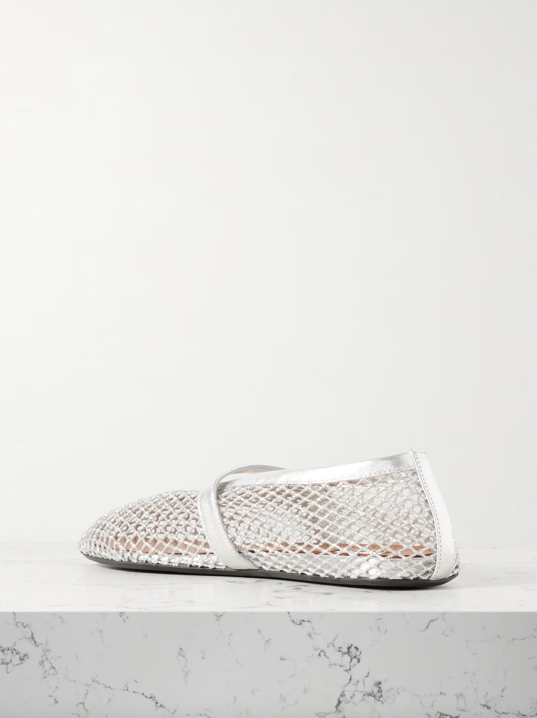 Elevate your wardrobe with Alaïa's modern take on the classic ballet flat. Crafted in Italy from silver mesh and metallic leather straps, these flats add a touch of glamour to any ensemble. With their comfortable round toes, they're perfect for everyday wear.