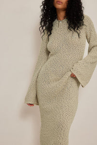 Get ready to turn heads with our Merryl Knitted Dress! This stunning maxi dress features a unique knitted design that will keep you comfortable and stylish all day long. The deep back, tied at the neck, and wide sleeves add a touch of elegance to this dress. Available in beige, it's the perfect addition to your wardrobe for any occasion.