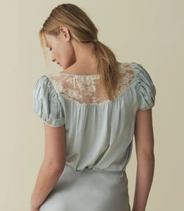 The luxurious Camri Top exudes an effortless style and understated elegance. Crafted from buttery silk satin, it features short puffed sleeves and delicate lace detailing at the yoke. Inspired by the glamour of the 1930s, it is completed with a delicate silk satin tie at the center front. Elevate your wardrobe with this timeless piece.