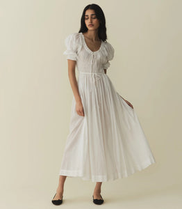 In a soft, lightweight blend of organic cotton and viscose, our beloved Ischia Dress—a Favorite Character that first made its debut in Spring 2021—features double-puffed sleeves and a scoop neckline adorned with petite ruffles and a functional center tie. A smocked bodice with an adjustable waist tie gives way to an ankle-grazing A-line skirt.