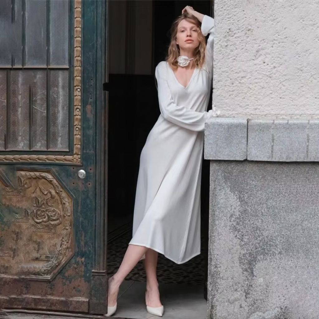 Make a statement with our versatile and timeless V-neck dress in a creamy hue. Perfect for any occasion, from parties to weddings to spring strolls. This dress complements a variety of accessories, allowing you to express your unique style. A must-have for your wardrobe, never going out of style.