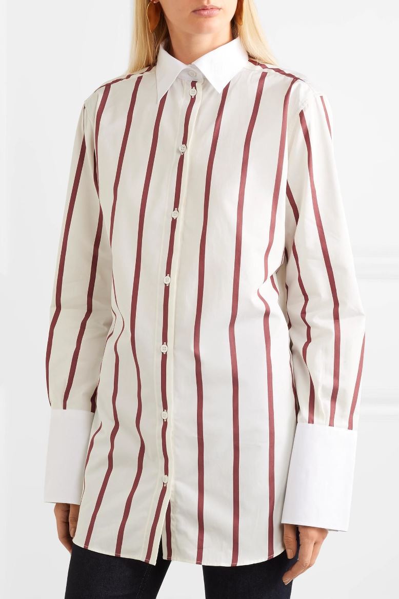 Unleash your business savvy with the 'Sassa' stripe shirt from Toteme. This stylish piece features bold burgundy stripes on a crisp white base, with a classic button-through design and oversized fit. Complete with a subtle monogram on the collar and a curved split hem, this shirt is the perfect balance of sophistication and playfulness. Get ready to make a statement in this must-have piece!