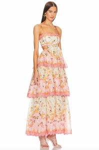 The Laurel Frill Gown is a stunning choice for any special occasion. Its straight neckline with scallop cut detail and tiered frill skirt add a touch of femininity and fun. The lace-up corset back is adjustable for a comfortable fit on various body shapes. Perfect for weddings, baby showers, and garden events.