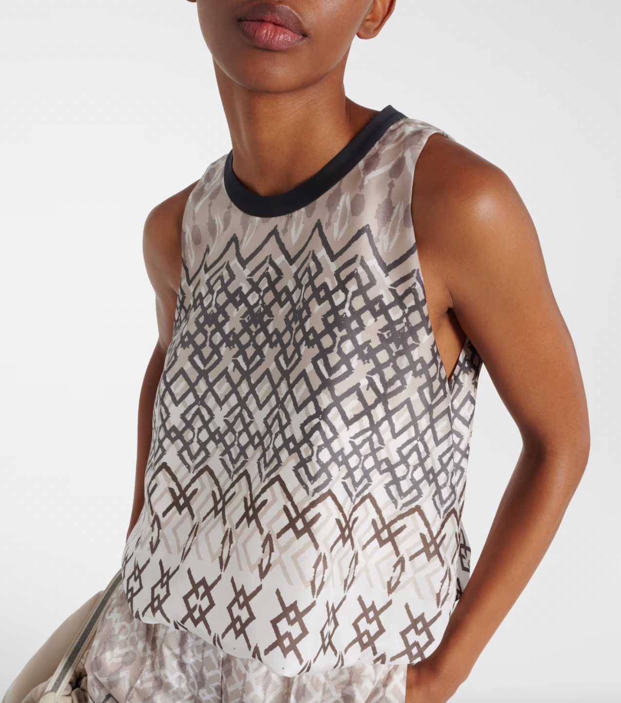 Elevate your wardrobe with the Printed Silk Top by Brunello Cucinelli. This sleeveless top features a playful puffed hem for a flared shape, adding a touch of ethnic whimsy to any outfit. Perfect for those looking for a unique and stylish addition to their wardrobe.