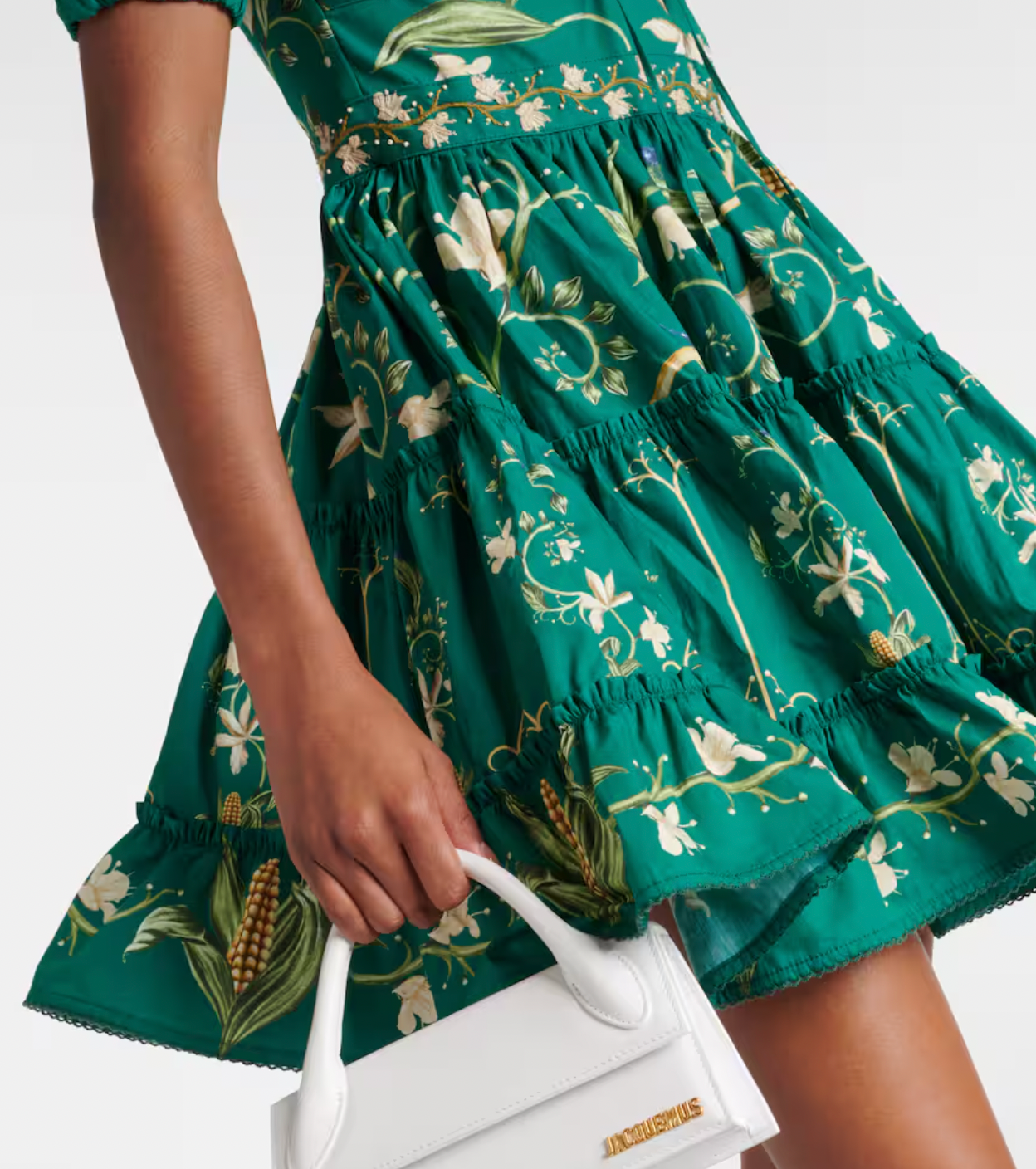 The Manzanilla Mini Dress in Neutral showcases tropical-inspired design through vibrant prints and a breezy, flattering silhouette. Made from 100% cotton poplin, it offers breathability and comfort. Key features include a deep V-neckline with an adjustable drawstring for a customized fit, short puff sleeves that add a touch of elegance, and a tiered A-line skirt that enhances movement and shape. 