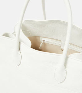 Introducing the Soft Margaux 17 Bag in White by The Row, now in luxurious grained leather. Handcrafted in Italy, this spacious tote is the perfect blend of style and comfort. Twin rolled handles, gusseted sides, and toggle closure make it both functional and fashionable. Upgrade your everyday with this must-have accessory.