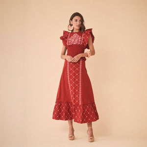 The Ensemble Blanca is a luxurious top and skirt set made of maroon cotton with stunning ethnic embroidery. The gathered waist top includes elastic and maxi ruffles on the shoulders, while the skirt features a high waist with a matching waistband and front embroidery. This set is perfect for any summer event or daily wear, adding a touch of elegance and style to your wardrobe.