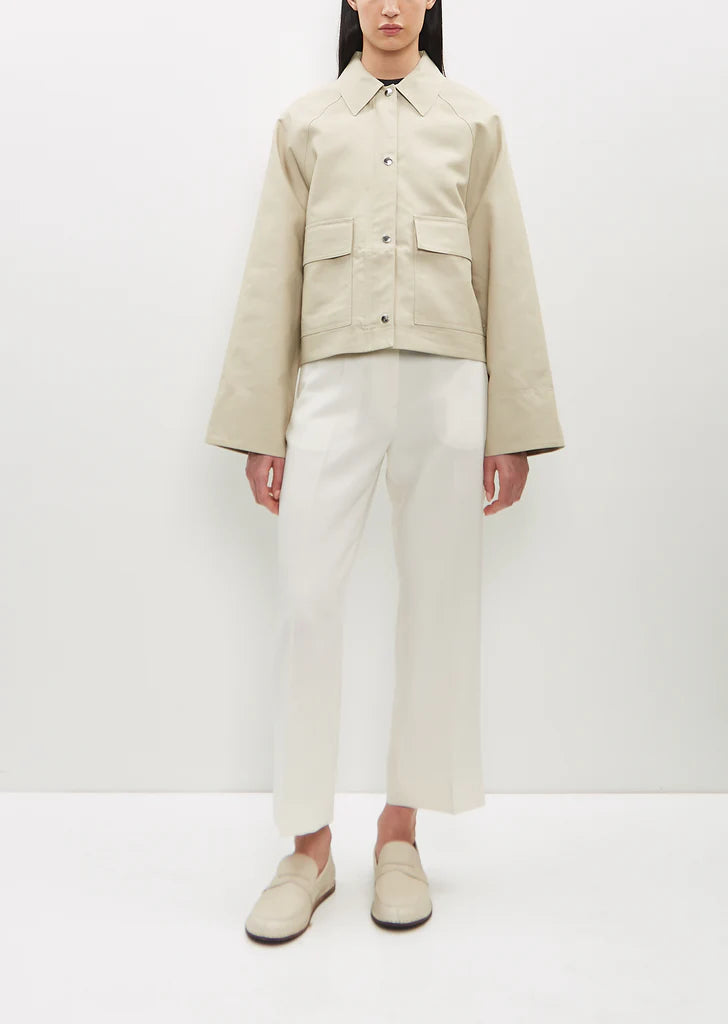 Elevate your everyday wardrobe with this sand beige cropped jacket by Toteme, crafted from sustainable organic cotton twill for a refined, eco-conscious choice. The boxy silhouette offers a contemporary silhouette that flatters effortlessly, while the spread collar and raglan sleeves deliver relaxed sophistication. Practical deep flap pockets keep essentials within reach, and the combination silver-tone zipper and press buttons closure provides versatile styling options. 