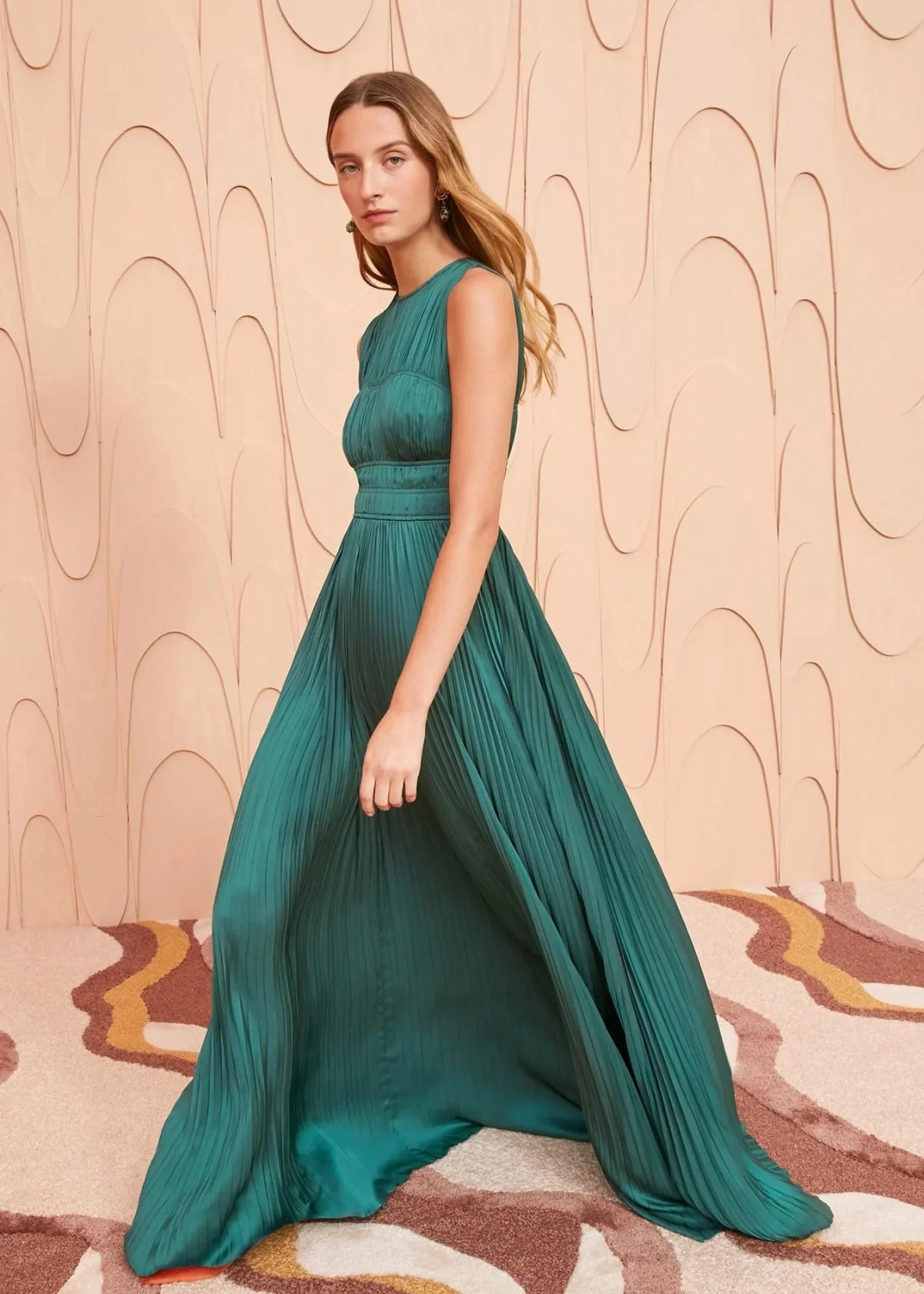 The Delia Gown is made from our gleaming signature plissé satin in a rich jewel green. This sleeveless dress has artful piping along the bodice, is gently elasticated at the waist, and falls to a fully pleated, gown-length skirt. It fastens with a concealed side-seam zipper.