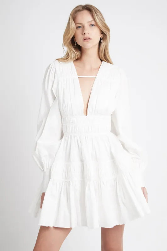 This Fallingwater Gathered Mini Dress by Aje showcases a deep V-neckline highlighted with delicate self-bind threading and elegant ruching panels that sculpt the silhouette. The gathered waist enhances shape, while side seam pockets add functional detail. Blouson sleeves gathered into wide cuffs offer a refined yet comfortable fit. Fully lined and featuring an invisible center back zipper, this dress provides both sophistication and ease, making it an impeccable choice for refined occasions.