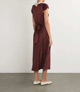 The Silk Lace-Trim Coraline Midi Dress channels the refined elegance of the 1930s with expertly crafted details. Made from lush silk satin, it gracefully drapes the body, enhanced by whimsical gathered cap sleeves. The plunging V-neckline highlights delicate embroidered scallop lace, while the fitted bodice transitions into a flattering bias-cut midi skirt. Adjustable back ties offer a personalized fit, and a subtle embroidered “D” on the bust adds a distinctive signature touch. 