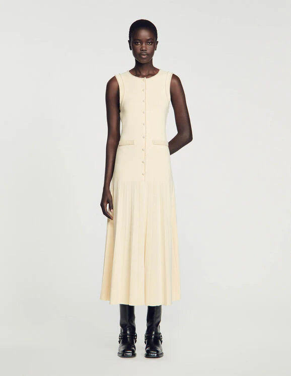 Introducing the SANDRO Knitted Midi Dress, exquisitely crafted from imported materials. This dress features a short front button fastening, two front patch pockets, and chic short sleeves. Its A-line silhouette adds a touch of sophistication to any wardrobe. Elevate your look with this luxurious and versatile piece.