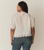 Load image into Gallery viewer, Crafted from lightweight, crisp ramie, the Idella Top from Doen features a plunging V-neckline, short puffed sleeves, and intricate embroidered lace details. Mother-of-pearl buttons adorn the front, while lace insets add delicate touches. This antique-inspired top is perfect for a breezy, feminine look.
