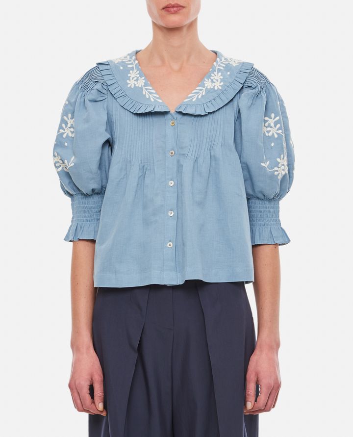 Introducing the Kyla Embroidered Cotton Blouse by Sea. This vintage-inspired blouse will add an air of sophistication to your wardrobe. Made with a breathable cotton and linen blend, it features delicate floral embroidery, ruffled collar, and pintucked details. Transform your look with this charming and unique piece.