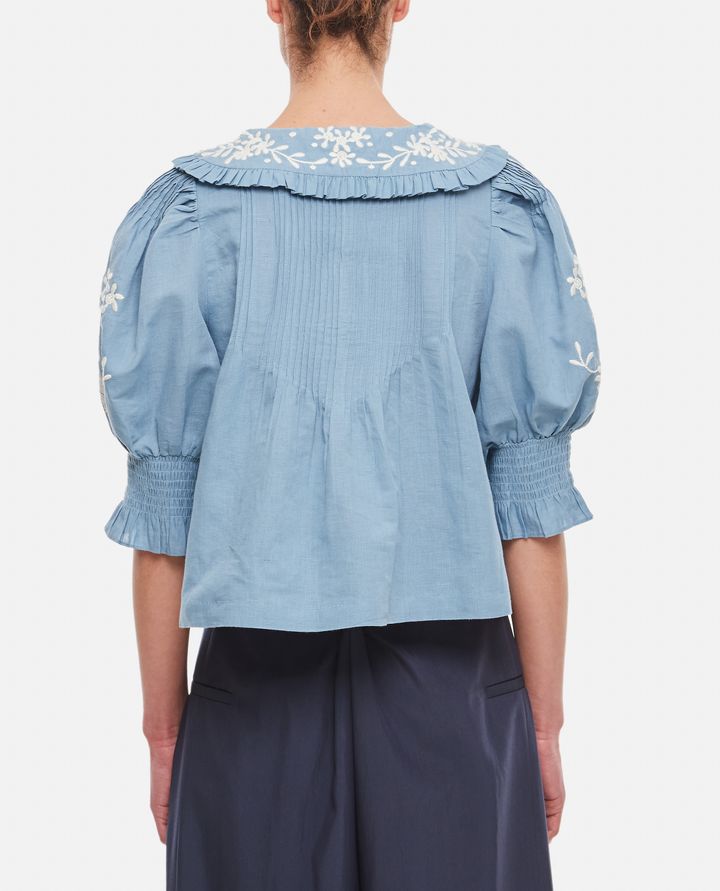 Introducing the Kyla Embroidered Cotton Blouse by Sea. This vintage-inspired blouse will add an air of sophistication to your wardrobe. Made with a breathable cotton and linen blend, it features delicate floral embroidery, ruffled collar, and pintucked details. Transform your look with this charming and unique piece.