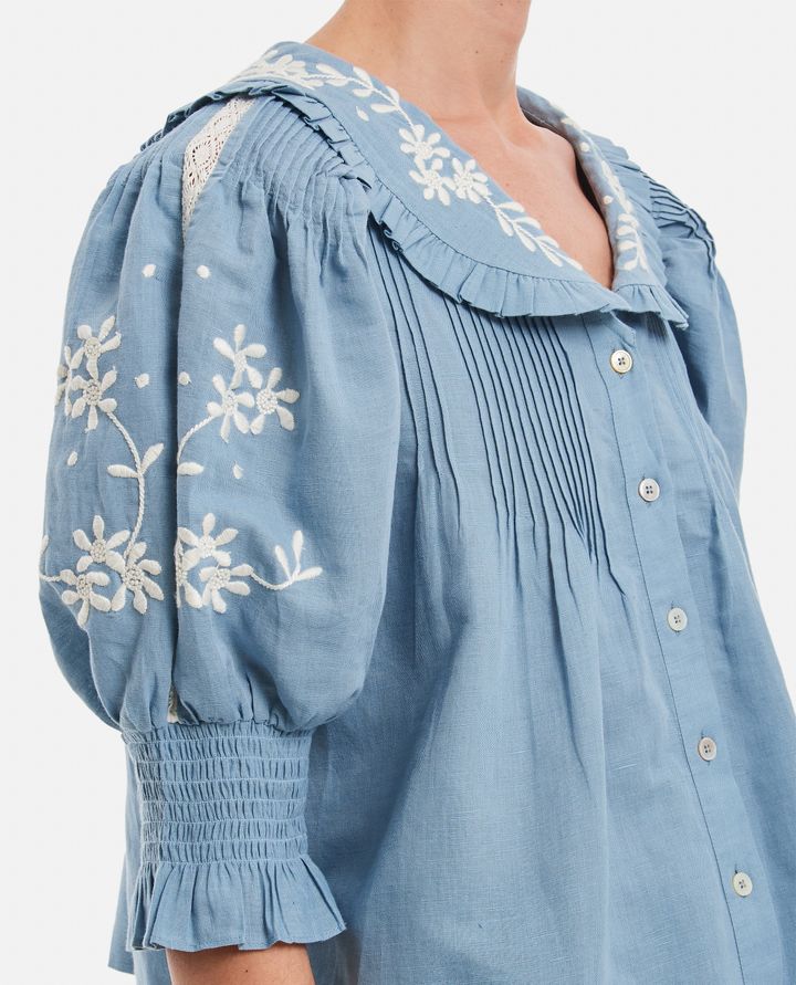 Introducing the Kyla Embroidered Cotton Blouse by Sea. This vintage-inspired blouse will add an air of sophistication to your wardrobe. Made with a breathable cotton and linen blend, it features delicate floral embroidery, ruffled collar, and pintucked details. Transform your look with this charming and unique piece.