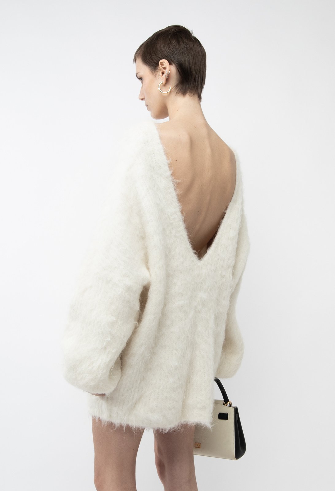 Elevate your wardrobe with the Gemini Sweater, a refined solid knit pullover designed to turn heads. Its daring backless style adds a touch of allure, while the loose fit and round neckline ensure all-day comfort. Long sleeves provide cozy warmth, making it the perfect blend of sophistication and ease. Step out confidently and make a memorable statement with this unique, stylish sweater.