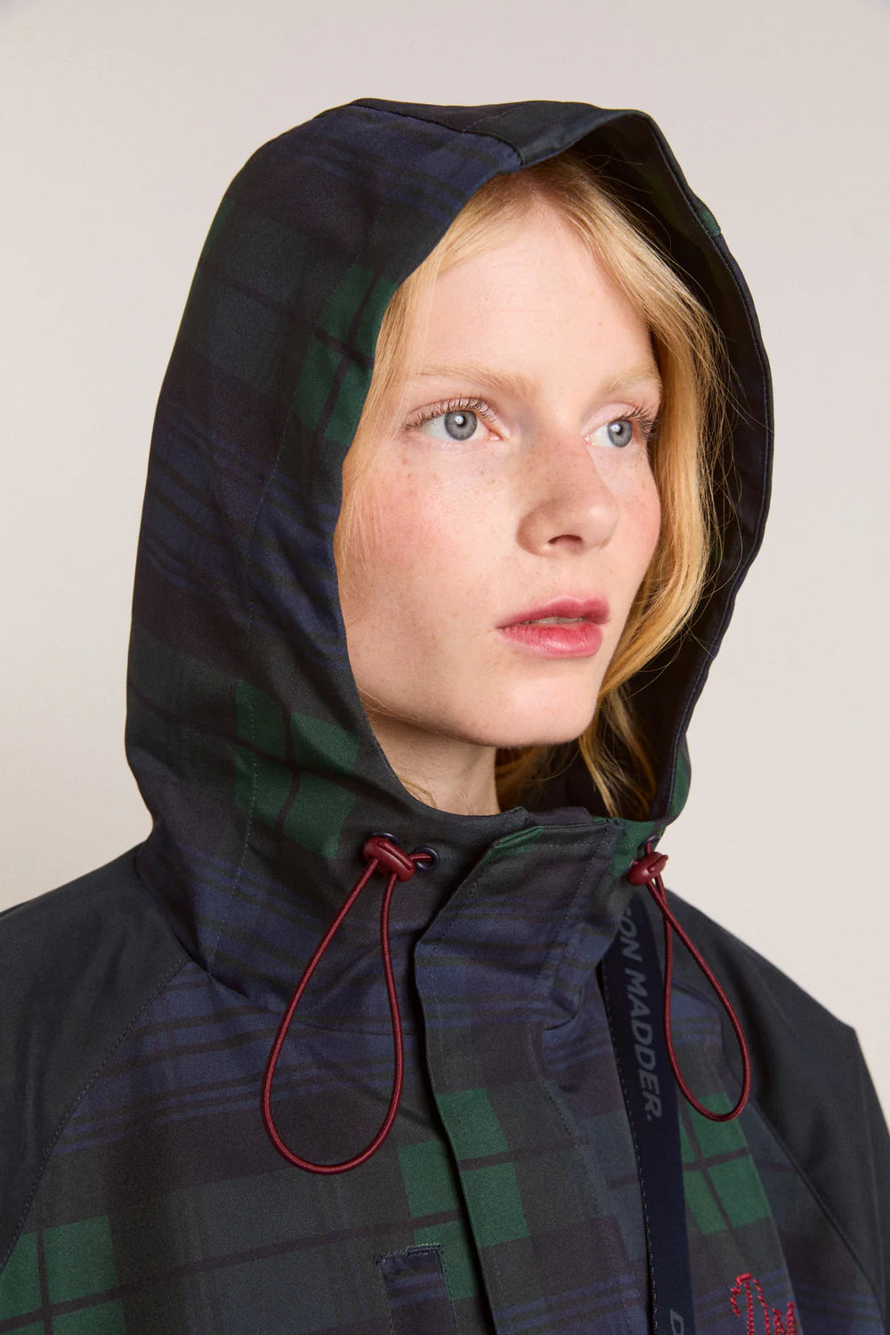 Embrace rainy days with the Liu Coat from Damson Madder, featuring a classic Black Watch tartan design crafted from shower-resistant fabric. Its balloon-style cuffs, adjustable hood, and cinchable waist offer both comfort and a flattering silhouette, while signature 'DM' embroidery adds a touch of distinction. Equipped with practical pockets and thoughtful details, this coat effortlessly combines style and functionality, making it the perfect shield against wet weather.