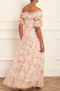 Indulge in the whimsical beauty of the Lana Off-Shoulder Gown. A hand-painted print of sunset and pink peonies adorns this signature Needle &amp; Thread style, while gathered frills add a romantic touch. The off-shoulder design with elasticated panels and layers of soft tulle creates a statement look. Plus, an internal corset with stretch power mesh ensures comfort and perfect fit.