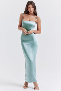 Indulge in luxury with our 'Constanza' dress, made from exquisite shimmering satin in a stunning light jade color. The corset-style bodice contours your curves while the delicate scalloped trim and barely-visible straps add a touch of elegance. The flowing maxi skirt with a slit allows for graceful movement and is fully lined for a smooth finish. 