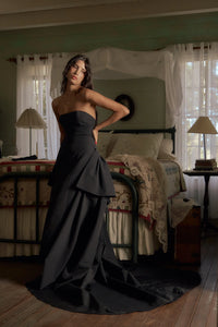 Be the life of the party in our Funny Face Gown Noir. Strapless column gown accentuates curves with built-in corset and hip padding. Side bustles and back peplum add playful flair. Functional buttons and invisible zipper down center back. Be the talk of the town in this daring and stylish gown!