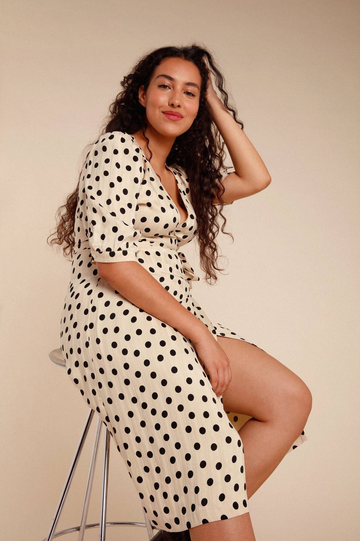 Introducing the Robe Caitlin - a stylish and versatile addition to your wardrobe. This knee-length jacquard dress features a wrap design, puffed sleeves, button accents, a waist-cinching belt, and back gathers for a flattering fit. Elevate any outfit with its playful polka dot pattern.