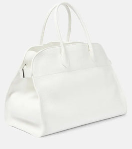 Introducing the Soft Margaux 17 Bag in White by The Row, now in luxurious grained leather. Handcrafted in Italy, this spacious tote is the perfect blend of style and comfort. Twin rolled handles, gusseted sides, and toggle closure make it both functional and fashionable. Upgrade your everyday with this must-have accessory.