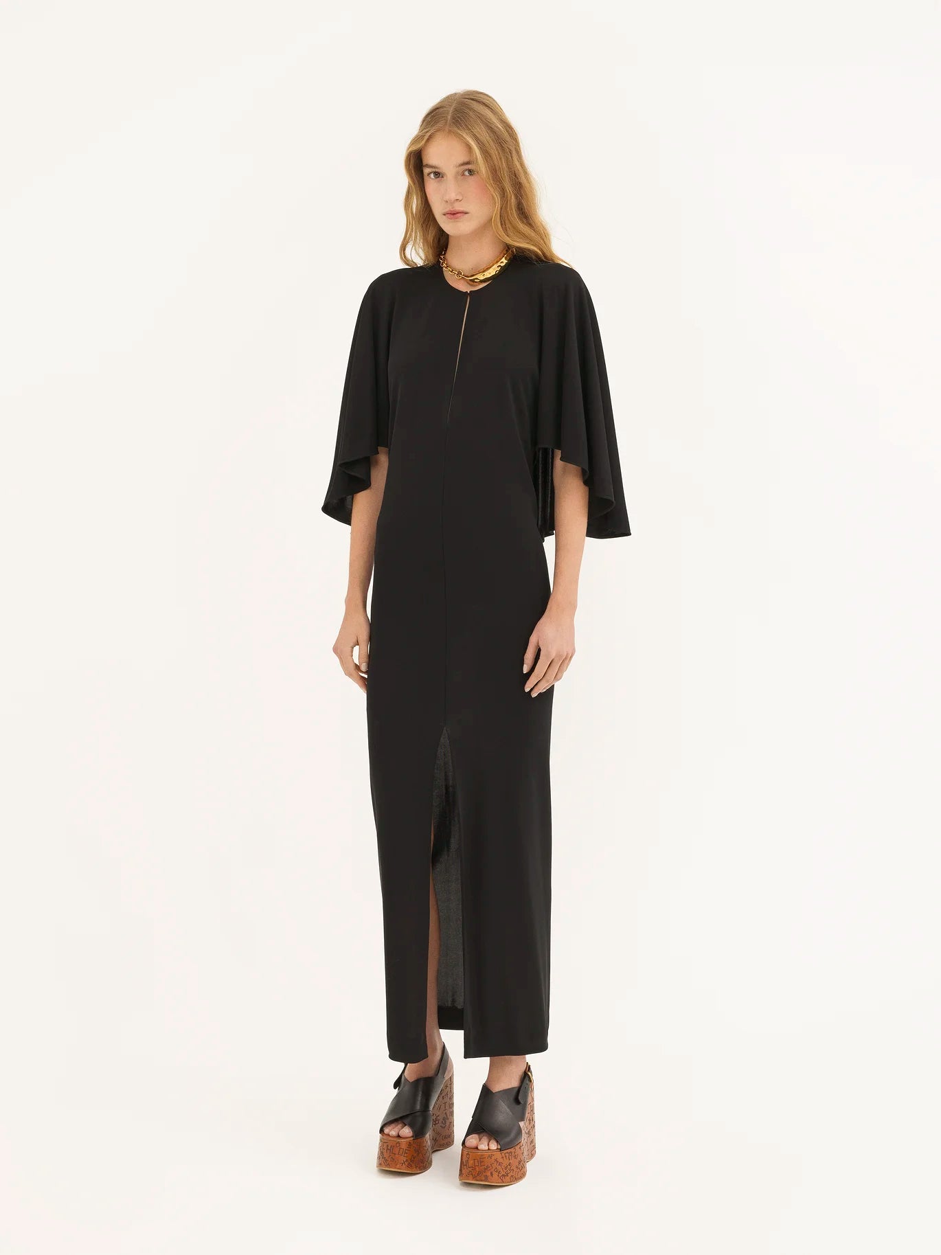 Add an elegant touch to your wardrobe with our Chloe Long Cape Dress. Crafted from luxurious fluid crêpe jersey, this dress exudes sophistication and grace. The flowing cape design adds a touch of drama, making it the perfect statement piece for any special occasion. Elevate your style with this exclusive dress.