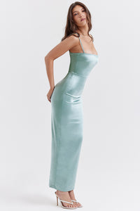 Indulge in luxury with our 'Constanza' dress, made from exquisite shimmering satin in a stunning light jade color. The corset-style bodice contours your curves while the delicate scalloped trim and barely-visible straps add a touch of elegance. The flowing maxi skirt with a slit allows for graceful movement and is fully lined for a smooth finish. 