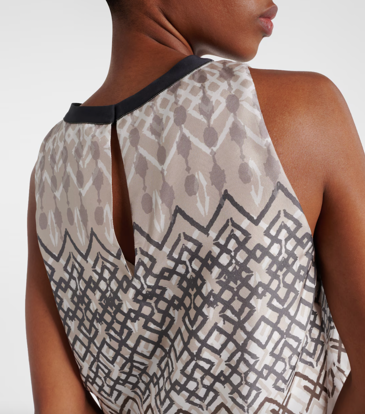 Elevate your wardrobe with the Printed Silk Top by Brunello Cucinelli. This sleeveless top features a playful puffed hem for a flared shape, adding a touch of ethnic whimsy to any outfit. Perfect for those looking for a unique and stylish addition to their wardrobe.