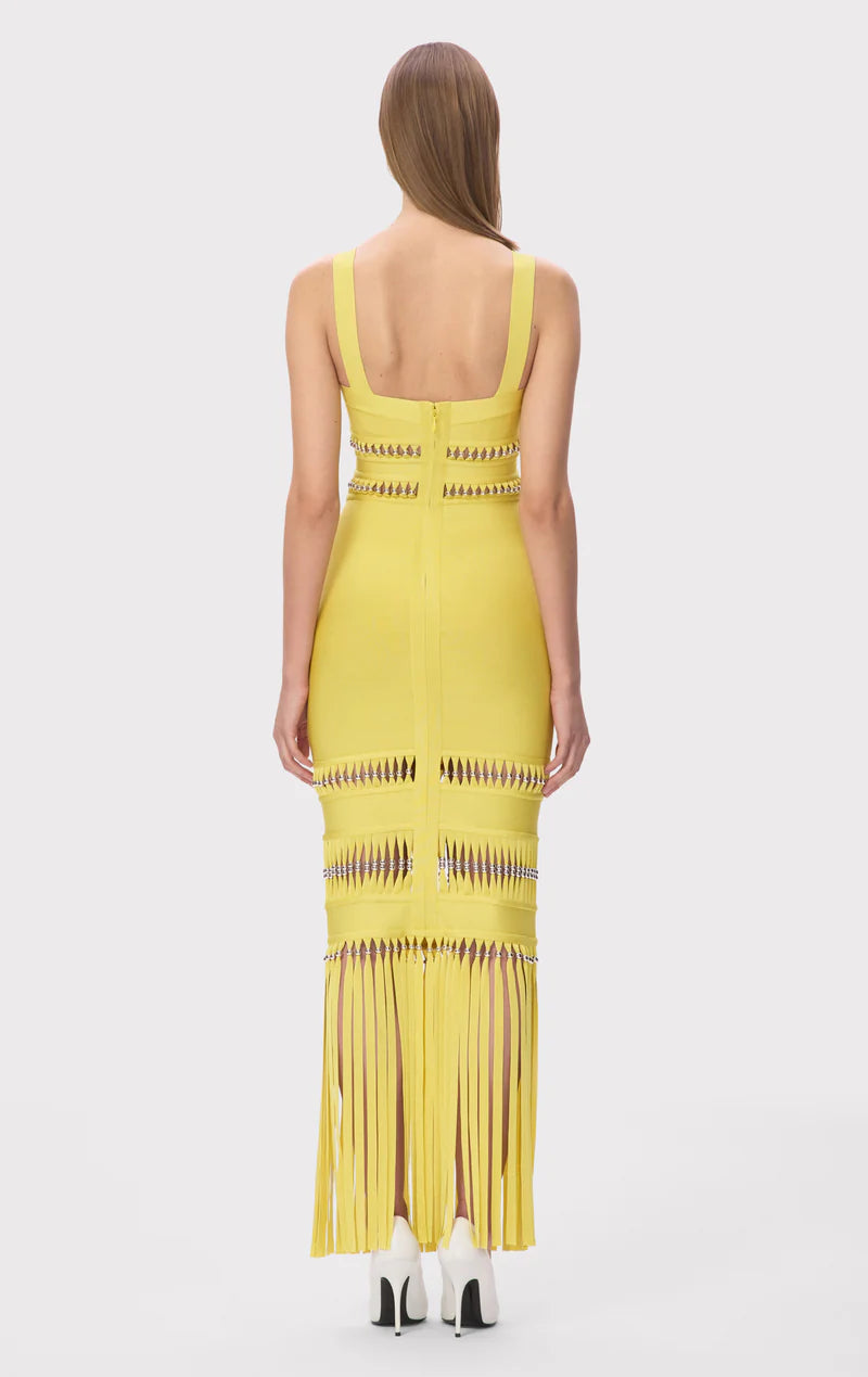 The Ines Gown by Herve Leger is a masterpiece of contemporary sophistication. Its body-contouring midi silhouette flatters every curve, while the striking square neckline commands attention. Hand-placed silver beads catch the light beautifully, creating an enchanting shimmer that draws the eye. Strategic cutouts offer tasteful glimpses of skin, adding an element of allure without compromising elegance. 