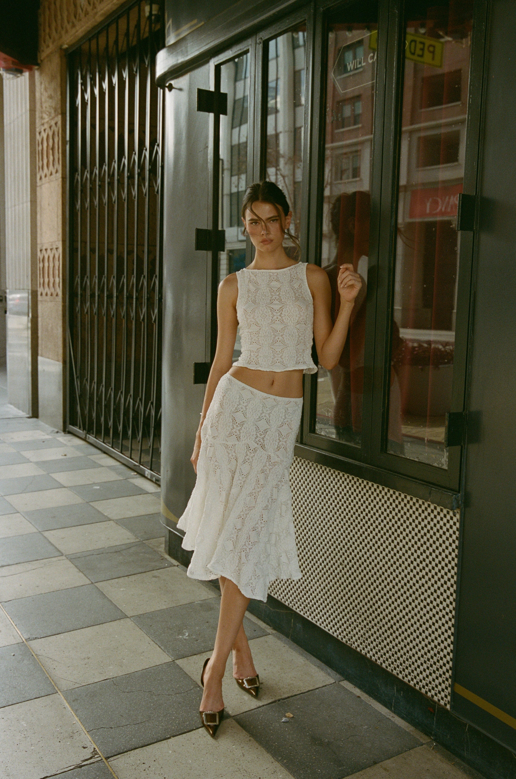 Elevate your summer wardrobe with the Ensemble Maeve 2 piece-set. The white, casual tank top is elevated with a trendy hollow out patchwork design, while the long skirt adds a touch of elegance. This sexy maxi skirt set allows you to effortlessly show off your personal style and stand out in any crowd. Perfect for any warm weather occasion.