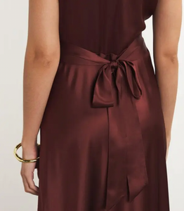 The Silk Lace-Trim Coraline Midi Dress channels the refined elegance of the 1930s with expertly crafted details. Made from lush silk satin, it gracefully drapes the body, enhanced by whimsical gathered cap sleeves. The plunging V-neckline highlights delicate embroidered scallop lace, while the fitted bodice transitions into a flattering bias-cut midi skirt. Adjustable back ties offer a personalized fit, and a subtle embroidered “D” on the bust adds a distinctive signature touch. 