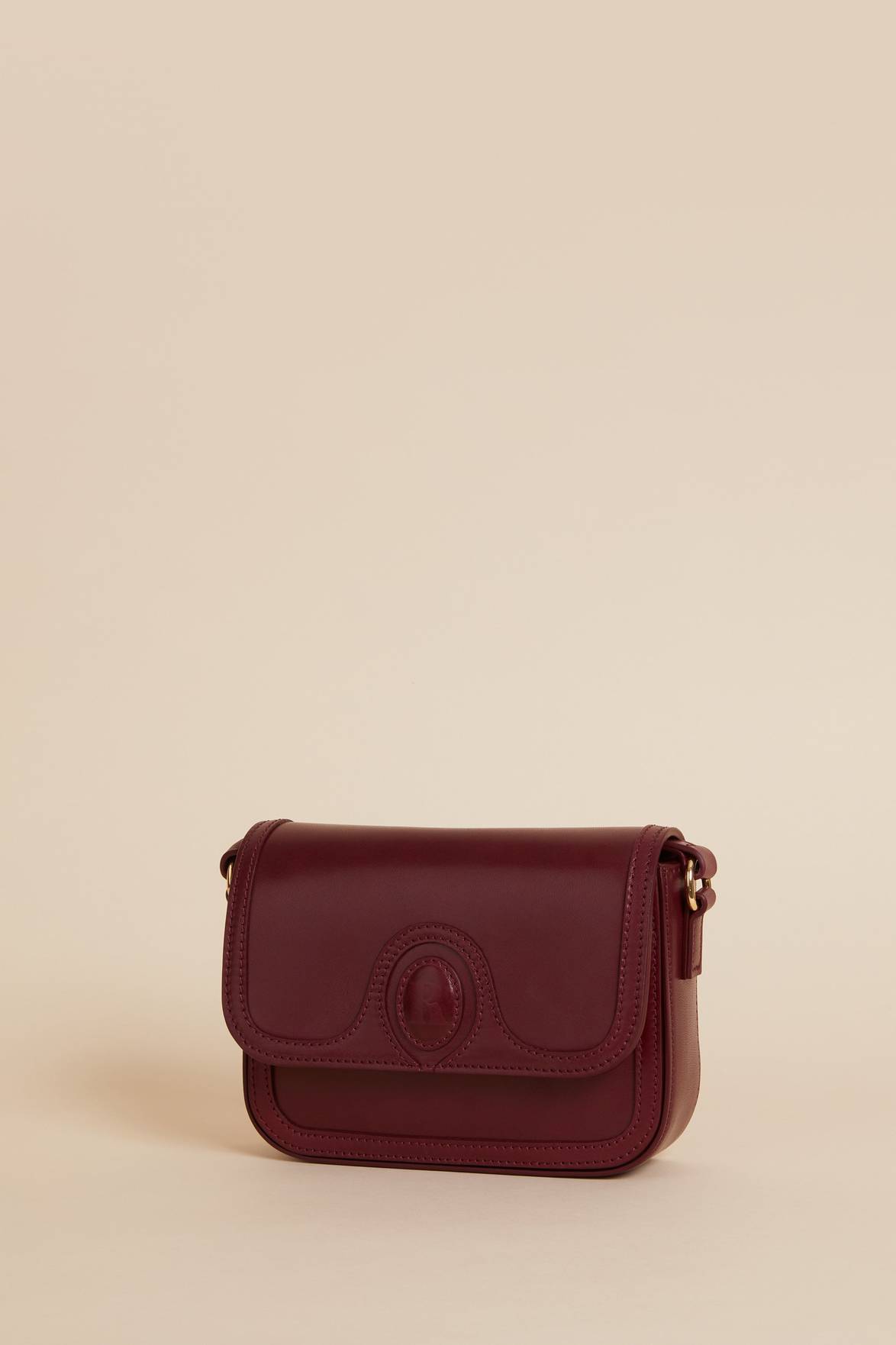 The Sac a main Bibi Nappa is the perfect accessory for any outfit. Made from 100% smooth cow leather, this small bag features a stylish "R" embossed flap with a magnetic closure. With its sleek design and bold burgundy color, it's both functional and fashionable.