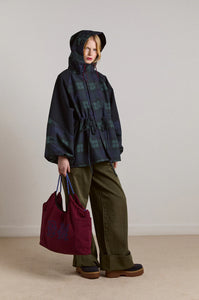 Embrace rainy days with the Liu Coat from Damson Madder, featuring a classic Black Watch tartan design crafted from shower-resistant fabric. Its balloon-style cuffs, adjustable hood, and cinchable waist offer both comfort and a flattering silhouette, while signature 'DM' embroidery adds a touch of distinction. Equipped with practical pockets and thoughtful details, this coat effortlessly combines style and functionality, making it the perfect shield against wet weather.