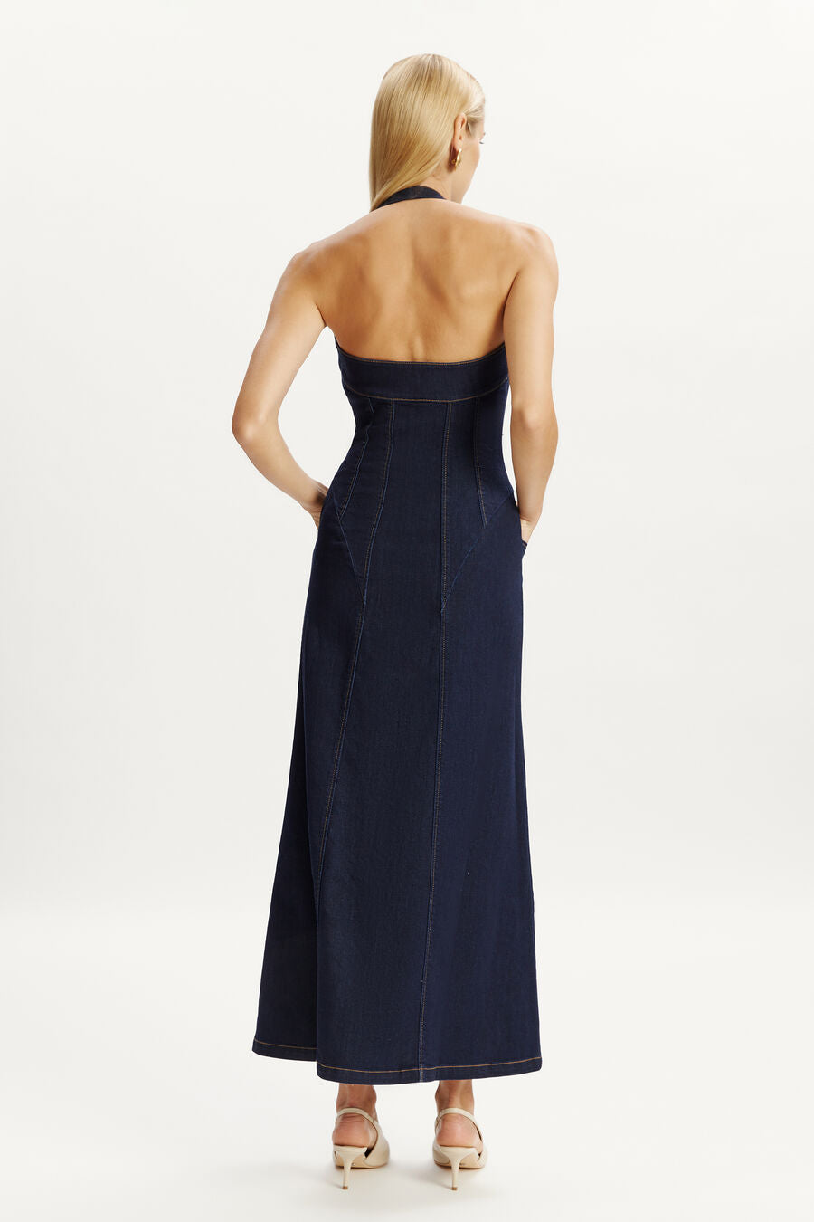 Discover the Martel Denim Midi Dress by Bardot—where casual charm meets refined elegance. This contemporary piece features a flattering halter neck and structured corset bodice that sculpts and supports, while the flared midi skirt with an open front split adds movement and sophistication. Practical side pockets keep you comfortable, and the versatile design transitions seamlessly from day to night. 