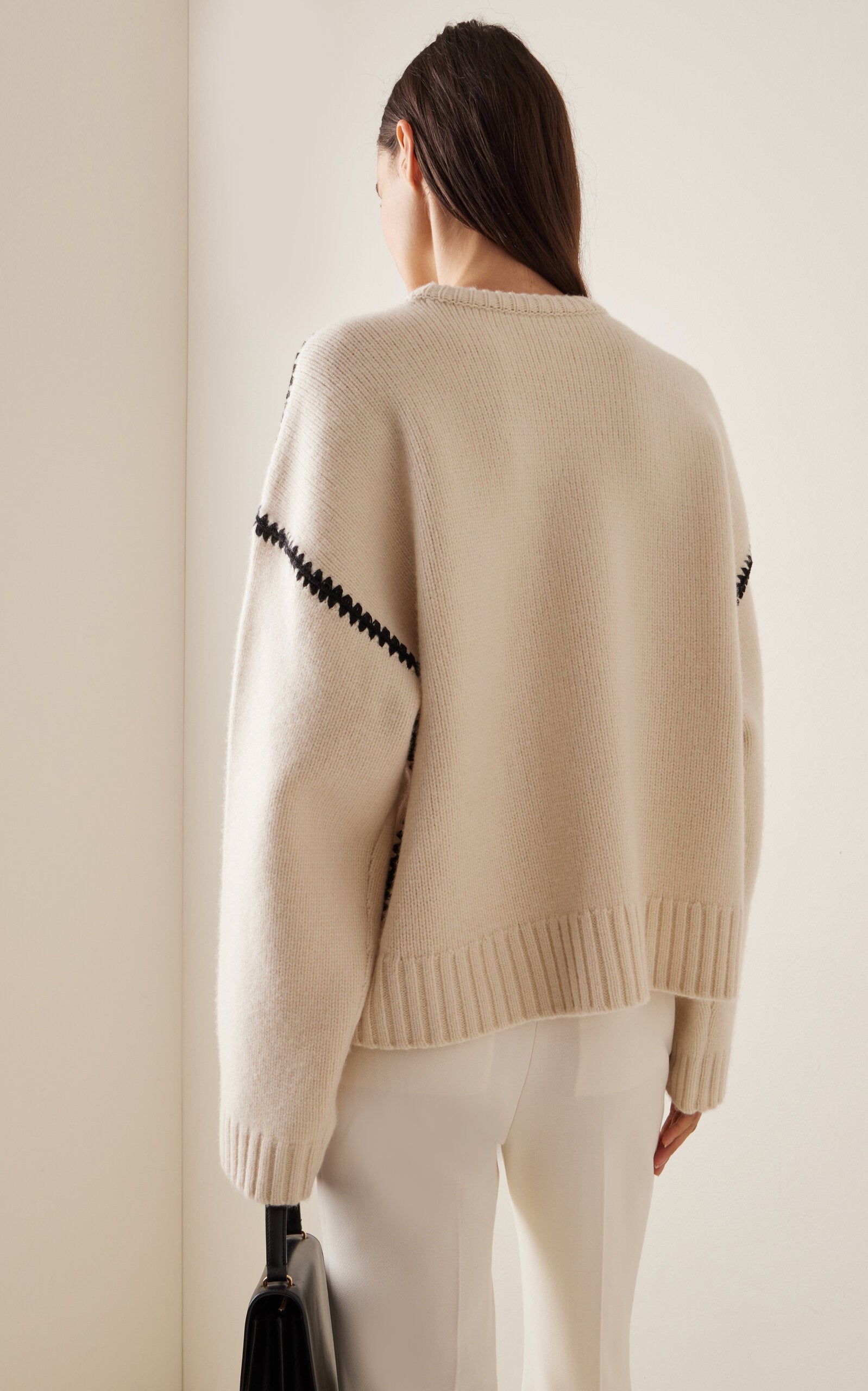 Embrace effortless Scandinavian style with this white wool-cashmere sweater by Totême. Crafted in a wide silhouette from mid-weight wool blended with cashmere, it offers cozy warmth and a soft touch. Intricate contrasting embroidery along the shoulders and armholes adds a refined, artisanal detail, elevating your everyday knitwear with subtle sophistication. Perfect for those who appreciate modern minimalism infused with a unique, handcrafted feel.