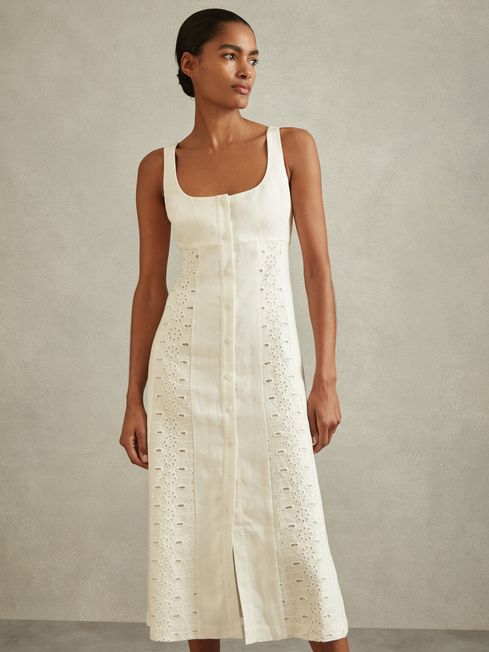 Indulge in summer luxury with the Clarice linen midi dress. This exquisite garment features intricate broderie detailing along the empire waistband and hem, while adjustable shoulder straps and a button-front closure allow for a customizable fit and flow. Made of 100% linen with a cotton lining, it's the perfect combination of elegance and comfort.