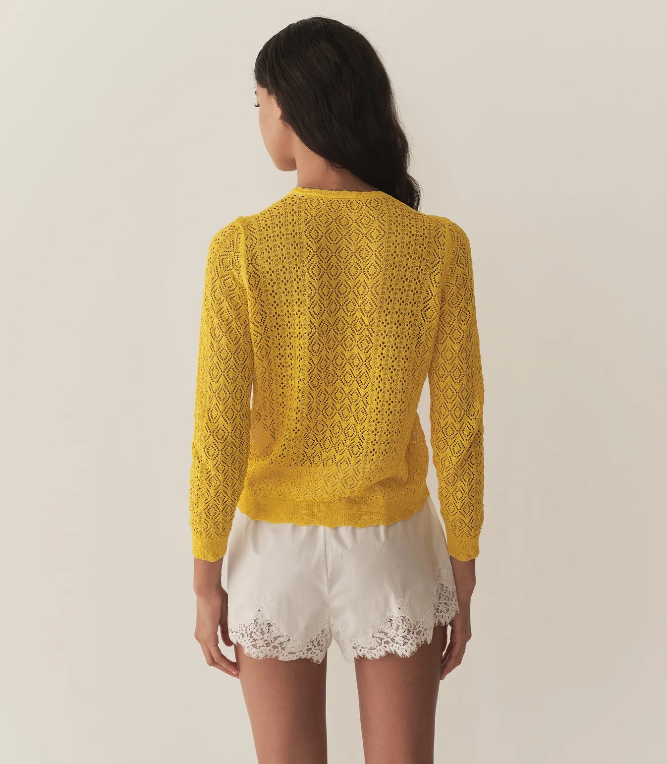 The Diane Cardigan by Doen is a wardrobe essential that effortlessly elevates any outfit with understated sophistication. Its intricate pointelle design draws inspiration from Victorian bobbin lace, creating visual interest while maintaining an airy, breathable feel. Crafted from a luxurious viscose blend, this cardigan drapes gracefully without excess weight, making it perfect for layering across seasons. 