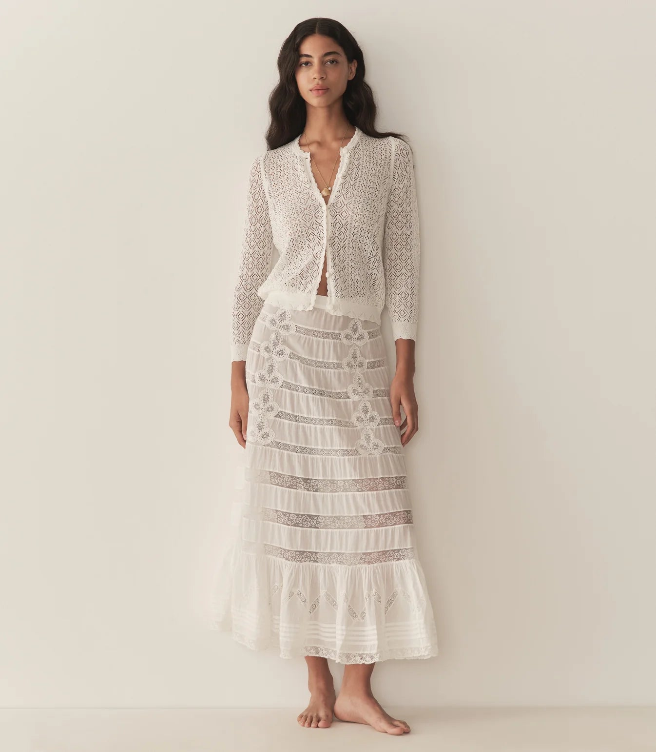 The Diane Cardigan by Doen is a wardrobe essential that effortlessly elevates any outfit with understated sophistication. Its intricate pointelle design draws inspiration from Victorian bobbin lace, creating visual interest while maintaining an airy, breathable feel. Crafted from a luxurious viscose blend, this cardigan drapes gracefully without excess weight, making it perfect for layering across seasons. 