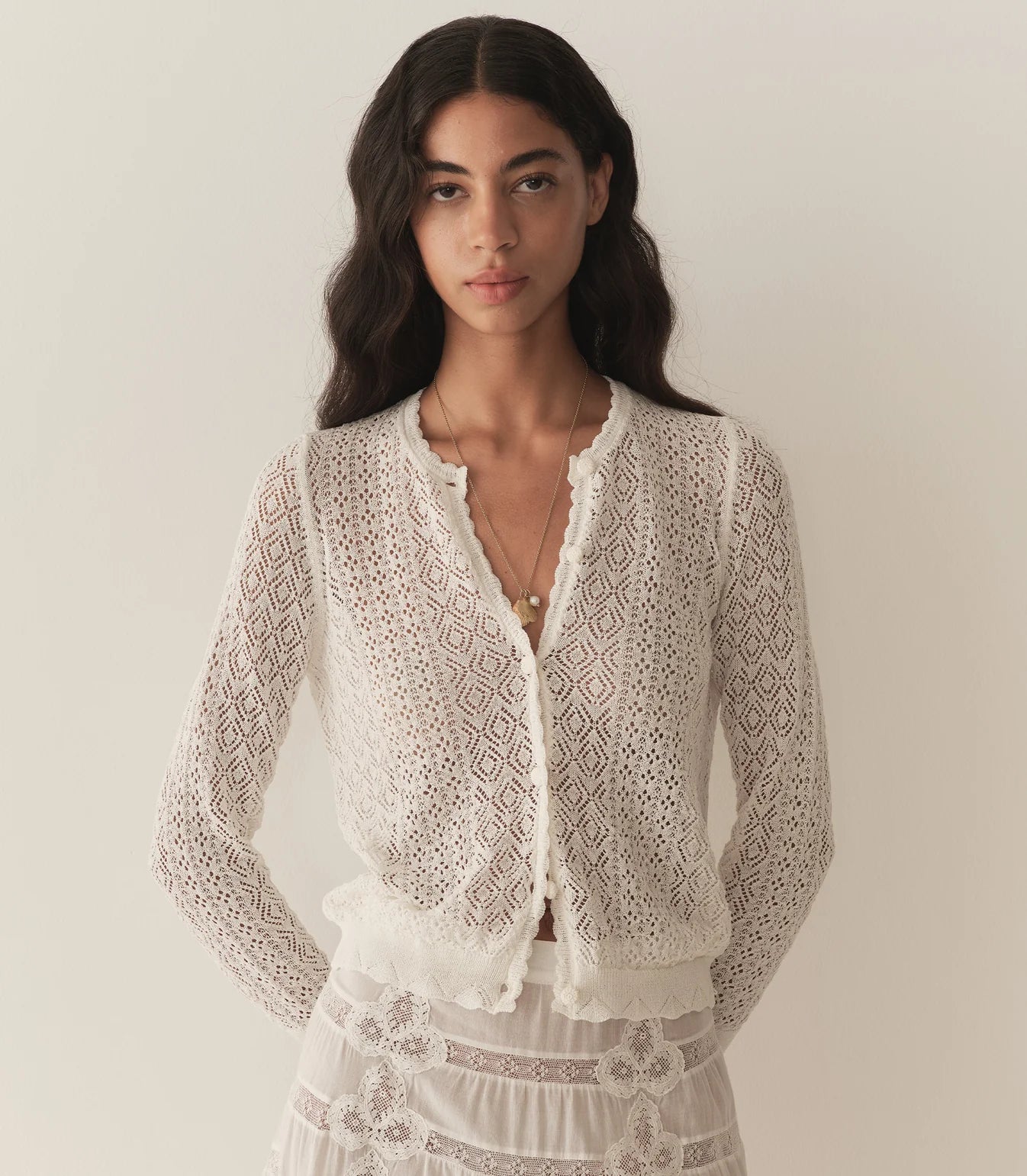 The Diane Cardigan by Doen is a wardrobe essential that effortlessly elevates any outfit with understated sophistication. Its intricate pointelle design draws inspiration from Victorian bobbin lace, creating visual interest while maintaining an airy, breathable feel. Crafted from a luxurious viscose blend, this cardigan drapes gracefully without excess weight, making it perfect for layering across seasons. 