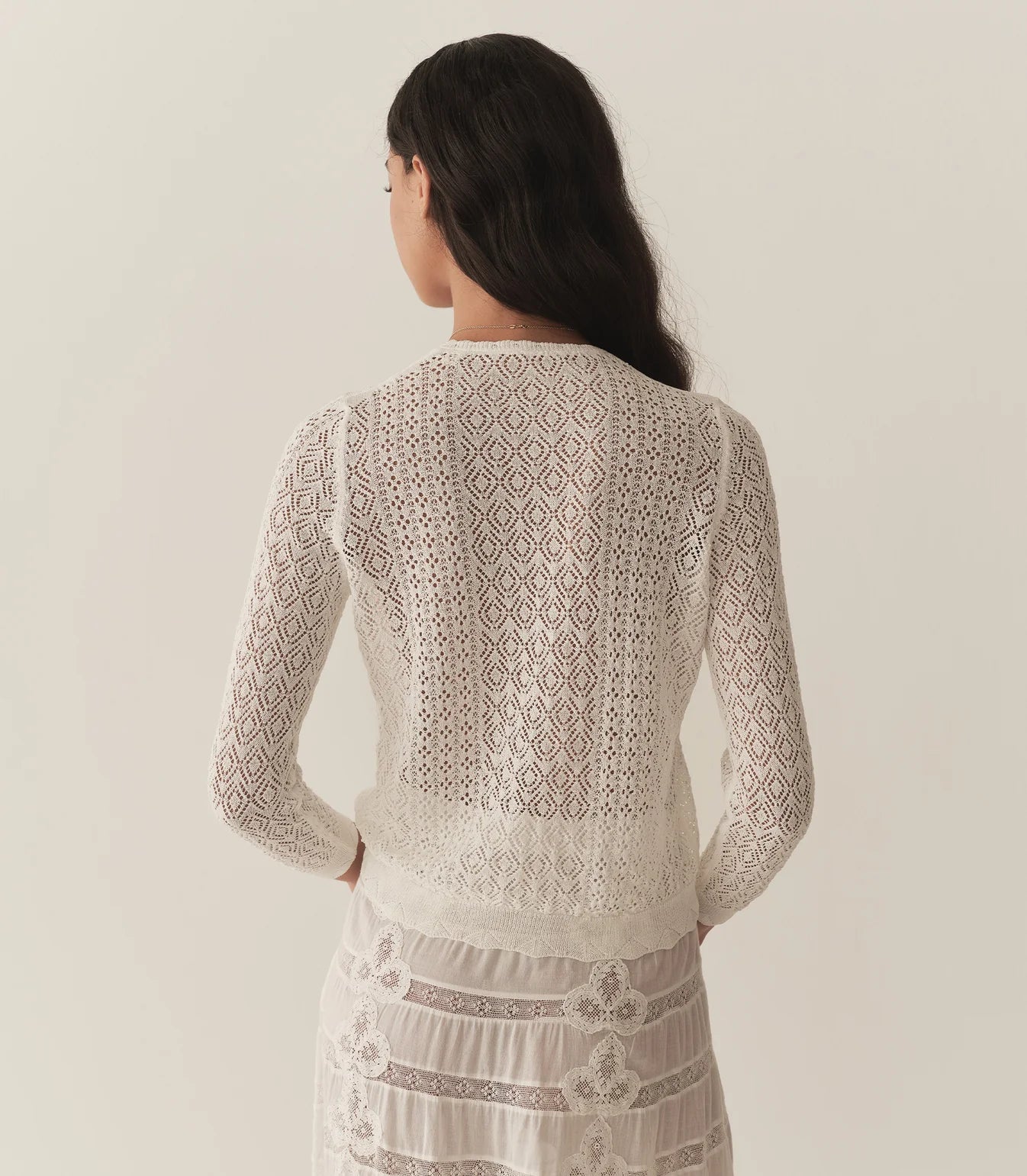 The Diane Cardigan by Doen is a wardrobe essential that effortlessly elevates any outfit with understated sophistication. Its intricate pointelle design draws inspiration from Victorian bobbin lace, creating visual interest while maintaining an airy, breathable feel. Crafted from a luxurious viscose blend, this cardigan drapes gracefully without excess weight, making it perfect for layering across seasons. 