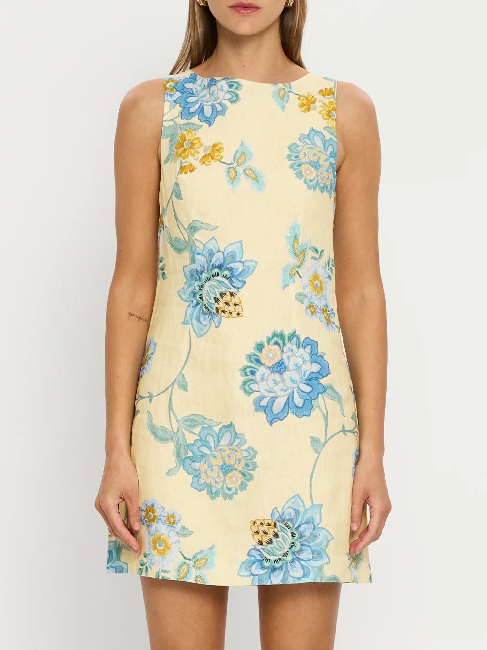 The Giselle Mini Dress combines intricate blue-toned vine florals with a fresh butter base, creating a refined and elegant look. Made from 100% linen, it offers breathable comfort and a lightweight feel ideal for warm weather. The dress features a sophisticated high boat neck and a square back neckline accented with contrast ties, adding a delicate, tailored finish to the silhouette. Perfect for those seeking both style and comfort, this piece seamlessly blends artistry with effortless wearability.